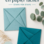 Enveloppes en papier faites maison sur une table avec des fournitures de bricolage.
