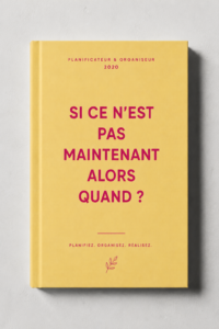 Une femme souriante utilisant un organiseur pour planifier son année.